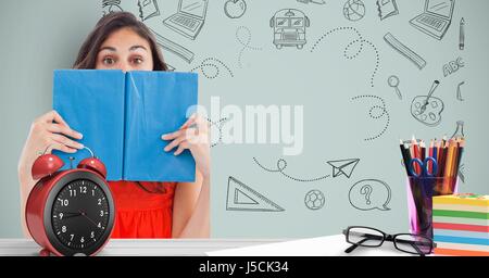 Digital Composite an Studentin hält Buch vor Gesicht gegen Grafiken Stockfoto