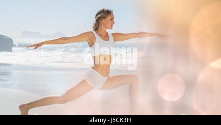 Digital Composite Fit jungen Frau praktizieren Yoga am Strand Stockfoto