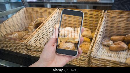 Digital Composite Hand fotografieren Brot durch Smartphone im café Stockfoto