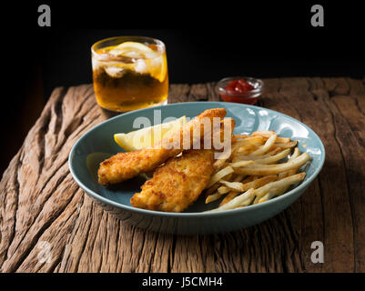 Frisch zubereiteter Fisch und Chips auf einem rustikalen hölzernen Hintergrund. Gastropub Stil essen. Stockfoto