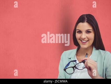 Digital Composite Porträt von glücklich weibliche Hipster hält Brillen vor rotem Hintergrund Stockfoto