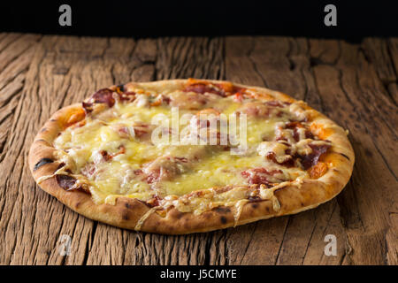 Frischer italienische Pizza serviert auf einem rustikalen Holztisch. Stockfoto