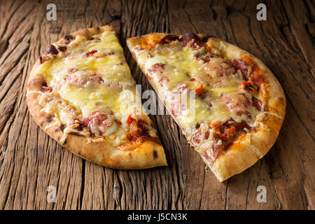 Frischer italienische Pizza serviert auf einem rustikalen Holztisch. Stockfoto