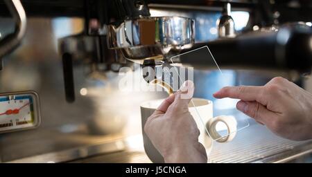 Digital Composite Hände fotografieren Kaffeemaschine durch transparente Gerät Stockfoto