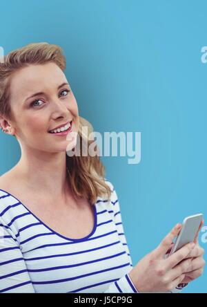 Digital Composite Porträt glücklich Frau mit Smartphone vor blauem Hintergrund Stockfoto