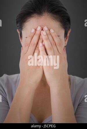 Digitalen Verbund von Frau Händen bedeckte Gesicht gegen graue Wand Stockfoto