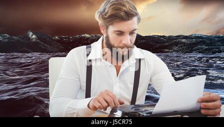 Digital Composite Hipster mit Schreibmaschine gegen See Stockfoto
