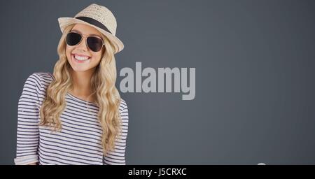 Digital Composite Porträt von glücklich weibliche Hipster trägt Sonnenbrille und Sonnenhut gegen grauen Hintergrund Stockfoto