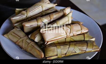 Suman sa Ibos ist eine philippinische traditionelle Köstlichkeit aus Glutenhaltigen Reis und Kokosmilch gewickelt in einen Behälter mit kunstvoll gefertigt Kokosnuss oder Palm verlassen Stockfoto