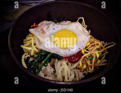 rak000736 Bibimbap, Reis koreanische traditionelle Speisen in heißem Stein Topf den Bibimbap ist garniert mit Gemüse, Sprossen, Nudeln, Ei und Fleisch Stockfoto