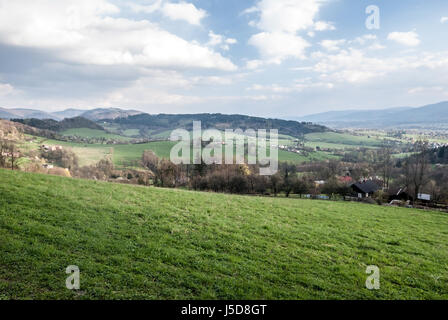 Frühling Landschaft der Beskiden in der Nähe von venndryne Dorf in der tschechischen Republik mit Wiesen, Häuser, Hügel und blauer Himmel mit Wolken Stockfoto