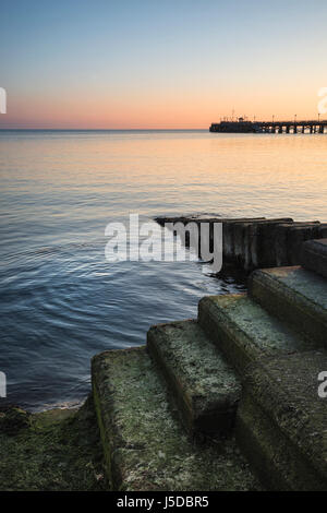 Schöne Langzeitbelichtung Landschaftsbild Schritte ins Meer während Frühling sunrise Stockfoto