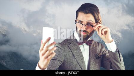 Digital Composite Hipster tragen Brille beim Lesen der Nachricht auf Smartphone Stockfoto