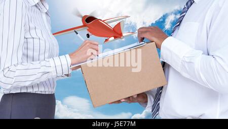 Digital Composite Mittelteil der Lieferbote unter Zeichen der Frau während der Bereitstellung Paket mit Flugzeug im Hintergrund Stockfoto