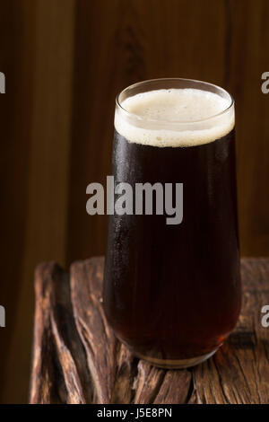 Ein Pint Bier sitzen auf einer urigen Holzbar. Kleinbrauerei Porter. Stockfoto
