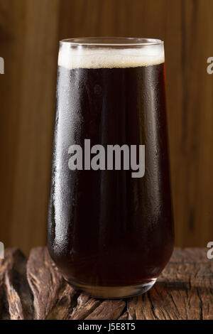 Ein Pint Bier sitzen auf einer urigen Holzbar. Kleinbrauerei Porter. Stockfoto