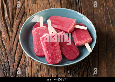 Hausgemachte Himbeeren und Vanilleeis erscheint auf einem rustikalen Holz Hintergrund. Berry Eis Eis am Stiel. Sommer essen. Stockfoto