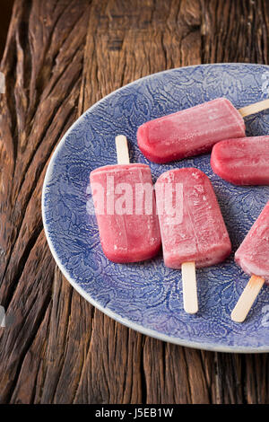 Hausgemachte Himbeeren und Vanilleeis erscheint auf einem rustikalen Holz Hintergrund. Berry Eis Eis am Stiel. Sommer essen. Stockfoto