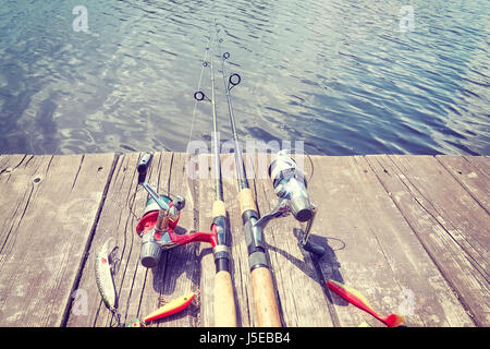 Vintage getönten Bild von Angelausrüstung mit künstliche Spinnen lockt auf einem hölzernen Pier. Stockfoto