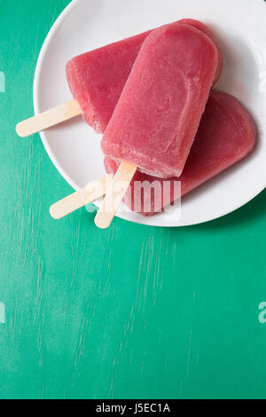 Hausgemachte Himbeeren und Vanilleeis erscheint auf einem rustikalen Holz Hintergrund. Berry Eis Eis am Stiel. Sommer essen. Stockfoto