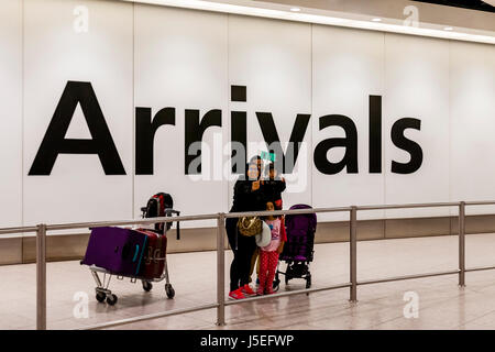 Eine Familie nehmen ein Selbstporträt In der Ankunftshalle des Flughafens Heathrow, London, UK Stockfoto