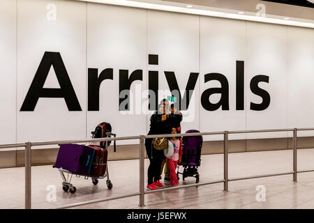 Eine Familie nehmen ein Selbstporträt In der Ankunftshalle des Flughafens Heathrow, London, UK Stockfoto