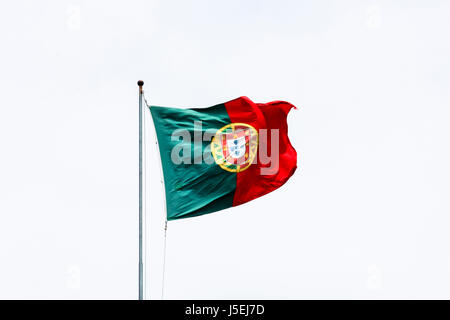Portugal Flagge am Mast flattern im Wind gegen bewölktem Himmel Stockfoto