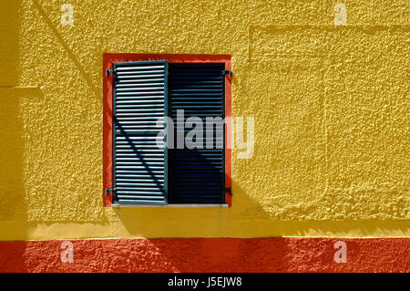 gelb bemalte Hauswand mit grünen Fensterläden, Sardinien, Italien Stockfoto