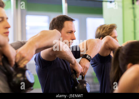 Gruppe von Menschen mit Kettlebells trainieren im Fitness-Studio Stockfoto