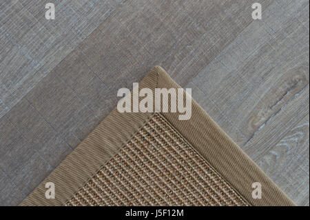 Ecke einer natürlichen Wolldecke auf einem Holzfußboden Stockfoto