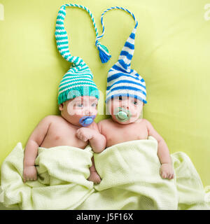 Zwillinge Baby Brüder Babys weared in gestreiften Hüte gebunden auswendig. Stockfoto