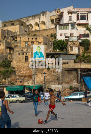 Syrische Flüchtlinge Kinder spielen Fußball vor Wohnungen und Gehäuse, North Governorate, Tripoli, Libanon Stockfoto