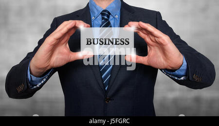 Geschäftsmann hält weiße Karte mit Business anmelden, grau - Stock Photo Stockfoto