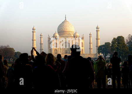 Eine Menge von Touristen sind Silhouette gegen den Morgenhimmel und das weiche Licht von der Sonne auf das Taj Mahal werfen, wie sie warten, bis die Tore öffnen. Stockfoto