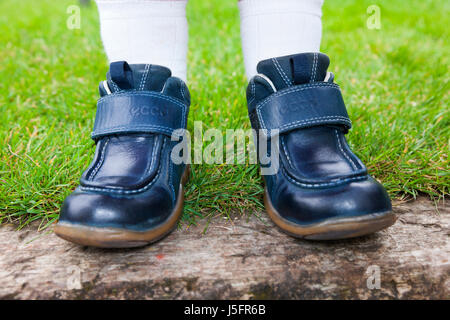 Kindes / Kinder / Jugendliche Kinder / Kinderschuhe am falschen Fuß, so setzen den rechten Schuh auf den linken Fuß auf der linken Seite auf dem rechten Fuß. (87) Stockfoto