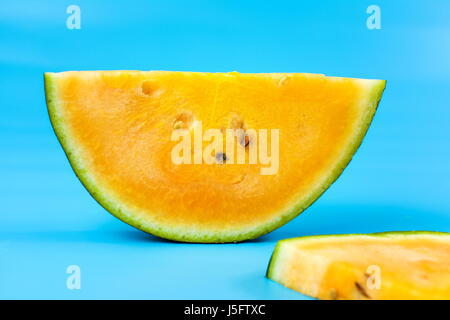 Gelbe Wassermelone Obst Scheibe vor blauem Hintergrund Stockfoto