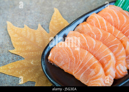 In Scheiben geschnittenen rohen Lachs auf schwarzen Druckplatte Stockfoto