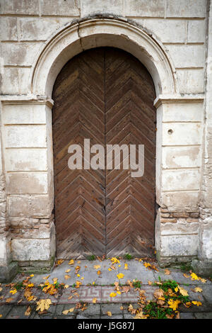 Holztür in einer alten Mauer Stockfoto