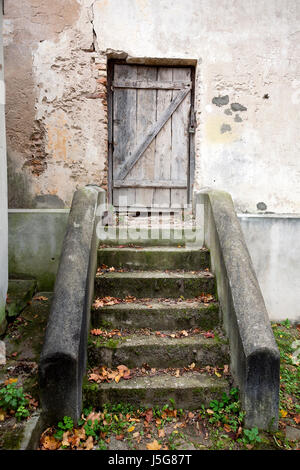 Treppen und Holztür in einer alten Mauer Stockfoto