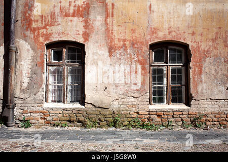 Im Alter von verwitterten Straße Wand mit einigen Fenstern Stockfoto