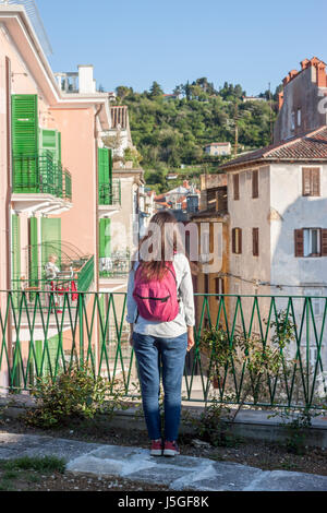 junge Frau sieht vom Balkon auf Italienisch Straße Stockfoto