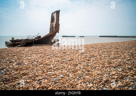 Bleibt ein alten hölzernen Fischerboot am steinigen Strand in Hastings, East Sussex, Großbritannien Stockfoto