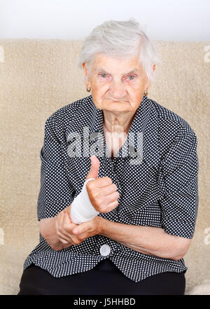 Eine ältere Dame mit bandagierten Handgelenk Stockfoto