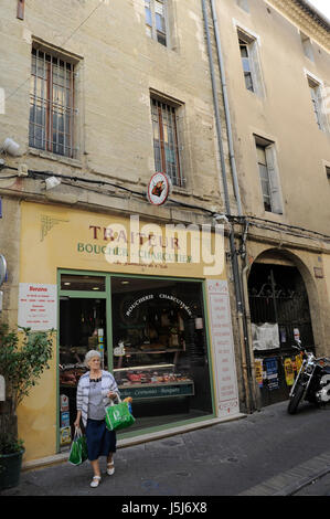 Eine Französin, die Einkaufen in einer Boucher und Wurstwaren (Metzgerei und Feinkost) in L'Isle-Sur-la-Sorgue, Frankreich Stockfoto