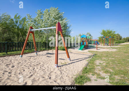 Kunststoff zwei Sätze auf der Erde Sand eingeschliffen Spielplatz mit Rutsche im öffentlichen Park Valdebebas in Madrid Stadt schwingen Spanien Europa Stockfoto