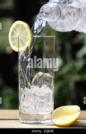 Mineralwasser in Glas gießen Stockfoto