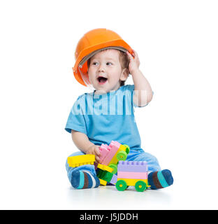 Kleinkind Kind in Bauarbeiterhelm spielt mit Klötzchen auf weißem Hintergrund Stockfoto