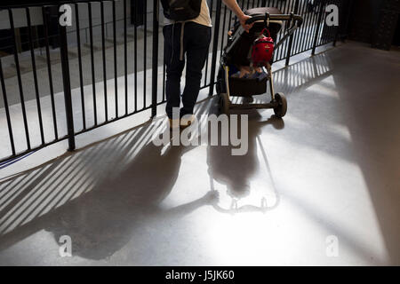 Ein Vater hält sein Kind Buggy in der Nähe von Geländern, die in London, England am 14. Mai 2017, die Turbine Halle des Tate Modern auf der Southbank übersehen. Stockfoto