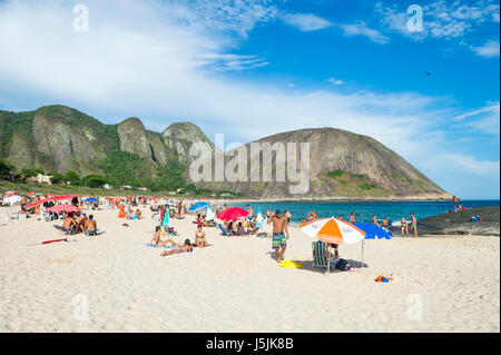 RIO DE JANEIRO - 4. März 2017: Beachgoers nutzen ein sonniges Wochenende in Itacoatiara Beach, ein Stadtteil in Niteroi über Guanabara-Bucht. Stockfoto