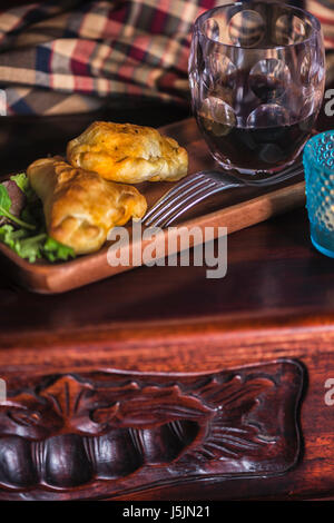 Stil aus Patagonien: zwei Empanadas und einem Glas Wein in ein schickes Refugium im Süden der Welt. Stockfoto